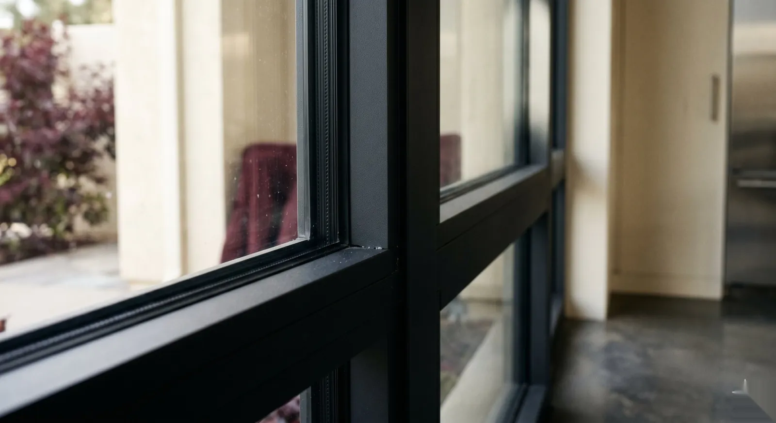 Profilés de fenêtre noirs en PVC, dormants et ouvrants alignés vus en gros plan.